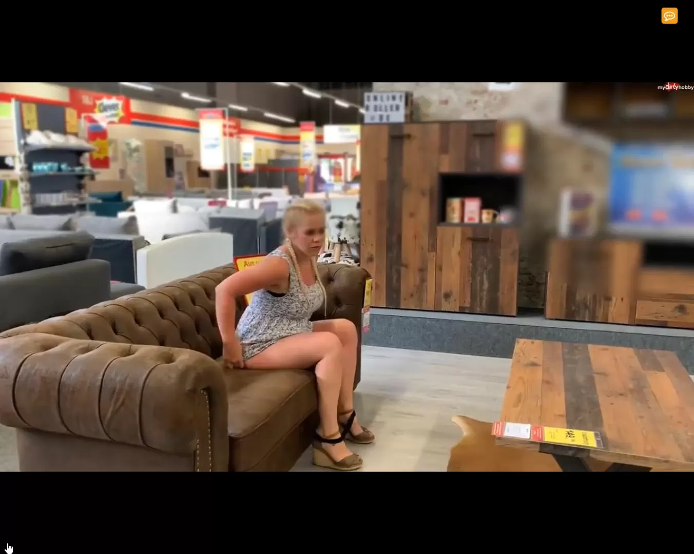 Woman pissing on a couch in furniture market picture